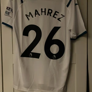 Manchester City vit bortatröja Mahrez 26 - Vit Manchester City fotbollströja med Mahrez och nummer 26 på ryggen. 