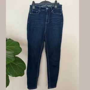 Mörkblå high rise jeggings från L.A. Star - Mörkblå skinny high rise jeggings från L.A. Star med smal passform och klassiska fickor. Byxorna är åtsittande och tajta men materialet av byxorna är väldigt stretchig. 