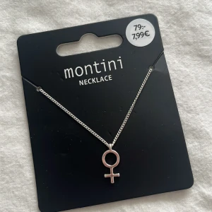 Silverfärgat halsband med kvinnosymbol från Montini - Säljer ett stilrent halsband från Montini med en silverfärgad kedja och ett hänge i form av kvinnosymbolen. Perfekt accessoar för att lyfta din outfit med en statementdetalj. Köpare står för frakt