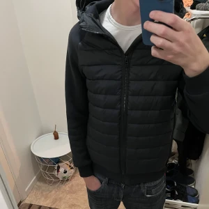 Svart cardigan - Säljer en svart cardigan från Superdry. Kostar  1300kr ny. Litet hål inuti fickan. 