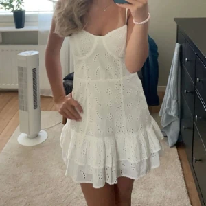 Vit broderad kortklänning med volang - Jätte söt och trendig miniklänning från bershka i storlek S i ett väldigt fint tyg. Den har snygg passform, ser ut precis som på bilderna och är perfekt till sommaren!🌸Dragkedjan är lite trög men fungerar fortfarande helt och klänningen är i mycket bra skick utan defekter. Skriv om du har några frågor eller vill ha fler bilder!💕