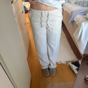Beiga linnebyxor - Säljer ett par beiga linnebyxor med normal passform och dragsko i midjan. Byxorna har raka ben och är perfekta för varmare dagar. Lätta och luftiga med klassisk look. Använda en gång💓