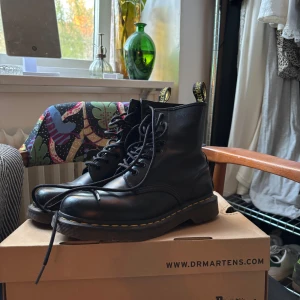 Svarta boots från Dr. Martens - Klassiska äkta svarta Dr. Martens med gul söm runt sulan och högt skaft. Skorna är i riktigt skinn och i gott skick!