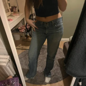 Levis 501 blå jeans - Klassiska blå Levis 501 jeans med rak passform och normal midja. Jeansen har fem fickor, knappgylf och Levis ikoniska läderpatch bak i midjan. Perfekta för en avslappnad och tidlös stil.