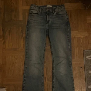 bootcut jeans - Säljer ett par mid waist utsvängda byxor. De har två slitningar vid grenen därav priset. Storlek 34