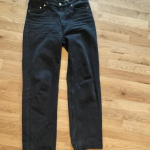 Svarta baggy jeans med låg midja - Säljer ett par svarta baggy jeans med hög midja. Klassisk femficksmodell i denim med raka ben och avslappnad passform. Perfekta för en chill och trendig stil.