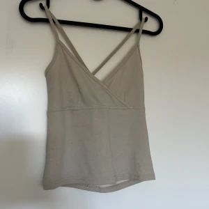 Beige omlott-linnetopp från Zoul - Säljer en beige linnetopp från Zoul med smala axelband och omlott-skärning framtill. Toppen har korsade band i ryggen. sista chansen annars slängs 🤍