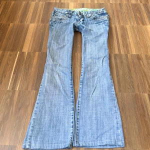 Ljusblå superlågmidjade bootcut jeans - Såååå sjukt snygga suuuperlågmidjade ljusblå bootcut jeans står storlek 26-32 men skulle säga xs! 💗💓 midjemått rakt över: 37 cm Innebenslängd: 65 cm, se bild