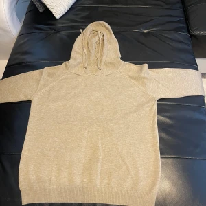 Beige stickad hoodie - Säljer en beige stickad hoodie som är för liten för mig. Perfekt nu till sommaren då det är ett tunnare material och riktigt skön. Tröjan är oandvänd. 