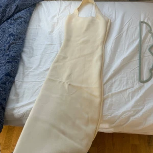 Ljusbeige ribbad långklänning från Zara - Säljer en ljusbeige ribbad långklänning från Zara med smala axelband och rak halsringning. Klänningen har en tight passform och är perfekt för sommardagar. Enkel och stilren design som är lätt att matcha.