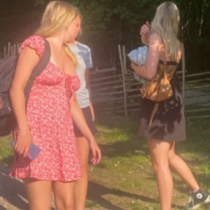 Blommig klänning - Söt röd klänning med blommönster och volangärmar. Klänningen har knyt framtill och är perfekt för varma dagar och somriga tillfällen!🤗