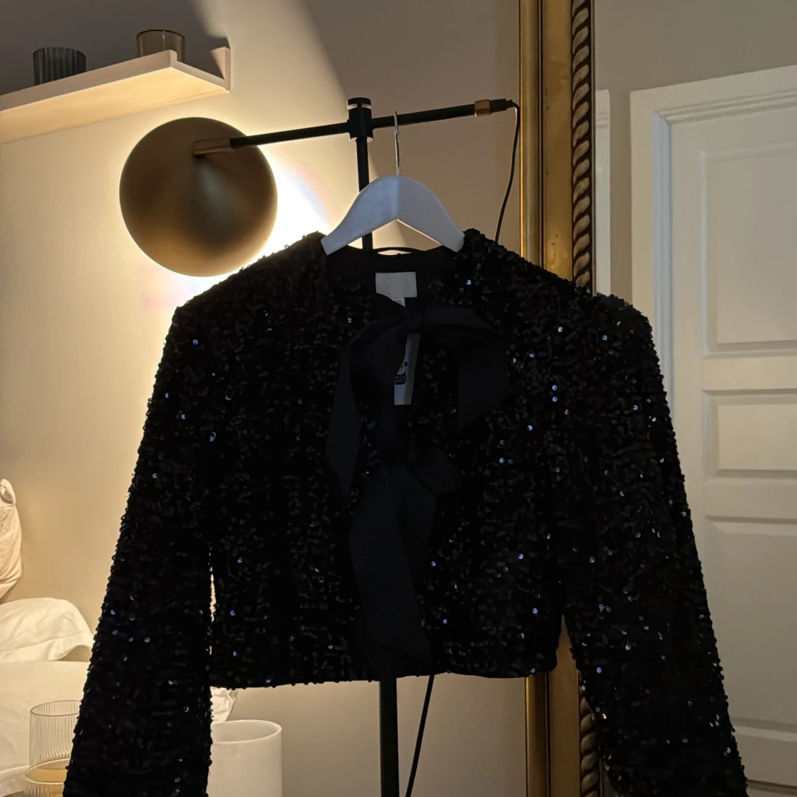 Svart paljettjacka med rosett från H&M