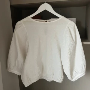 Vit blus från Carin Wester - Säljer en stilren vit blus från Carin Wester med trekvartsärmar och lätt struktur i tyget. Blusen har rund halsringning och knapp i nacken. Perfekt s/m skulle ja säga. Kommer tyvärr inte till användning.