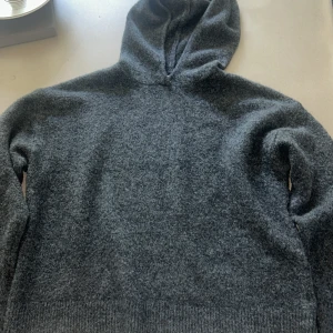 Mörkgrå stickad hoodie - Mysig mörkgrå hoodie i stickat material med huva och långa ärmar. Har användt en gång❤️