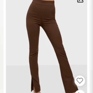 Bruna slim byxor med slits - Snygga bruna byxor med slim passform och hög midja. Byxorna har en stilren design med slits nertill på benen, vilket ger en trendig look. Det är från bianca x nelly och så gott som nya, använda en gång!
