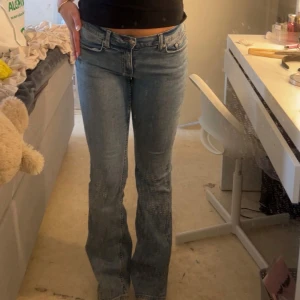 Blå bootcut jeans med hög midja - Snygga ljusblå jeans med bootcut-modell och låg midja. Klassisk femficksdesign och dragkedja med knapp framtill. Jeansen har en lätt utsvängd passform nertill och är tillverkade i ett mjukt denimtyg som sitter bekvämt.