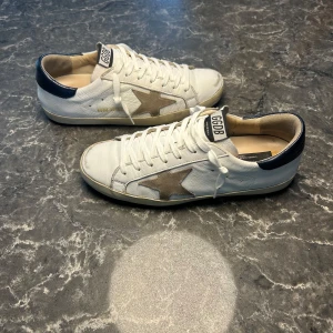 Golden Goose - Säljer ett par otroligt snygga skor från det exklusiva italienska märket Golden Goose i modellen Superstar! Skorna är i mycket bra skick, skulle säga ungefär 8,5/10 (OBS ”defekter” ingår från början). Nypris ligger runt 6000kronor men vi säljer våra för endast 2299! Skorna är storlek 41 men är lite stora i storleken. Skriv gärna ifall det är några funderingar, allt bästa SkoKapet