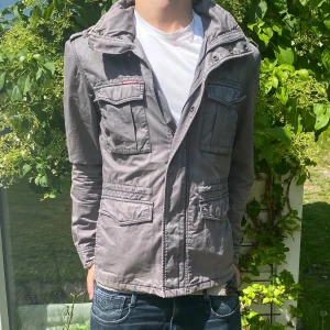 Superdry Jacka  - En galet fet superdry Jacka, med sjukt snygg grå färg! 🎨 | Jackan är även rätt tunn så fungerar perfekt till kalla sommardagar🌤️ | Jag på bilden är 185 | Hör av dig vid fler funderingar!👊