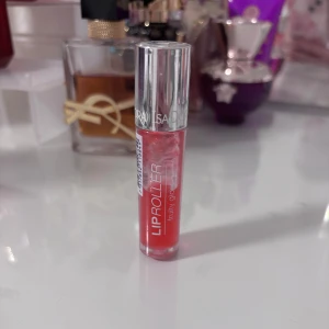 IsaDora Lip Roller Fruity Gloss - IsaDora Lip Roller Fruity Gloss i en fräsch rosa nyans. Kommer i en smidig genomskinlig tub med silvrigt lock och roller-applikator för enkel applicering. Ger glansiga, återfuktade läppar med en hint av färg och fruktig känsla.