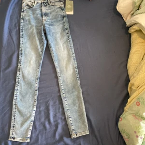 Skinny ljusblå jeans från H&M XS - Snygga skinny jeans från H&M i ljusblå tvätt med ultra hög midja och ankellängd. Klassisk femficksmodell och tillverkade i bomull med 20% återvunnen bomull. Perfekta för en clean och fräsch look.