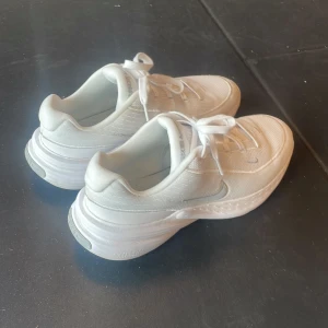 Vita Nike sneakers med tjock sula - Vita Nike inomhus gympa skor, har använt dem i en månad. Dem var för stora för mig… Skorna ser nästan helt nya.  Storlek 45. Original pris i stadium: 989 kr.