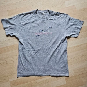 Huntington Beach - Vintage 90s Tee - Vintage T-shirt - Huntington Beach CA  Mycket fint skick!  Storlek: XL  90% Bomull 10% Polyester    Axelbredd: 54cm  Längd: 75cm