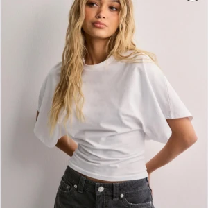 Nelly tröja - Säljer en vit croppad t-shirt med loose fit och korta ärmar, storlek S. Lappen är fortfarande kvar eftersom att den inte kommer till andvändning.