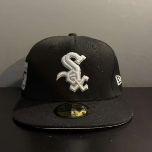 New Era keps - Tjaaaa!! Säljer en nästan helt ny New Era keps som är ett måste till sommaren!!!! Kepsen är värkligen i topp sick. Basballkepsen har ett WHITE SOX märke på framsidan och ett riktigt snyggt broderat märke på sidan. Fina inga skador eller fula missfärgningar. Alla klistermärken är kvar. Tveka inte att skicka ett meddelade om det minsta lilla. Storlek- 7-3/8 (58,7cm). 