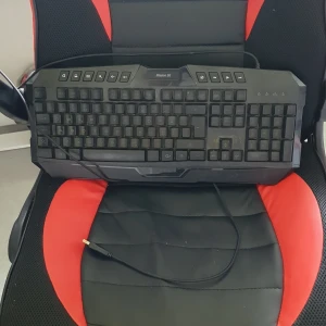 Tagentbord - Bilderna visar ett gamingtangentbord, modell Mission SG, med RGB-belysning och USB-anslutning. Tangentbordet har dedikerade mediaknappar och en robust design, perfekt för gaming eller studier.