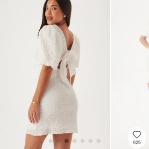 Vit kort klänning med puffärm och rosett - Superfin vit kort klänning med puffärmar och öppen rygg med knytrosett. Klänningen har en strukturerad yta och sitter tajt över kroppen. Använd 1 gång på studenten, inga tecken på användning 🌸Nypris: 599 kr