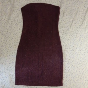 Brun glittrig tubklänning H&M Divided - Säljer en brun, glittrig tubklänning från H&M Divided i storlek XXS. Klänningen är kort, figurnära och axelbandslös med snyggt skimmer i tyget. Perfekt för dig som vill sticka ut med en enkel men glam look.