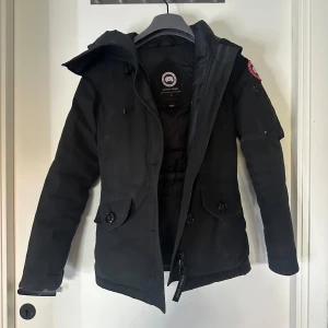 Svart vinterjacka från Canada Goose XS - Säljer en svart vinterjacka från Canada Goose med päls som är i storlek 2XS. Perfekt för kalla vinterdagar! Riktigt varm och stilren modell. Lite skavanker på den för har använt den 2 vintrar, det som e vid handleden är inget man ser eller lägger märke till :) innan den levereras så kommer den vara kemtvättad!