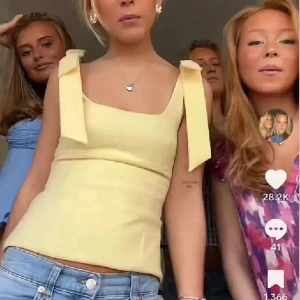 Gul linnetopp med knytband - Supersöt ljusgul linnetopp med breda axelband som knyts till rosetter. Toppen har en rak, figurnära passform och fyrkantig ringning. Perfekt för en fräsch och somrig look, lätt att matcha med jeans eller kjol. Helt ny, endast testad❤️