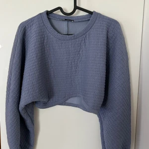 Blå croppad tröja från Zara - Supermjuk och quiltad blå croppad tröja från Zara. Tröjan har lång ärm, rund halsringning och en loose fit som ger en chill vibe. Perfekt till jeans eller mjukisbyxor för en avslappnad look.