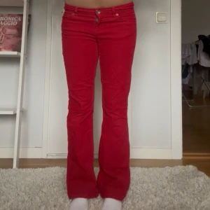 Röda bootcut manchesterbyxor - Manchesterbyxor från tommy hilfiger. Lågmidja och bootcut. Midjemått och innerbenslängd finns i bilderna