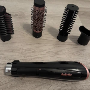 BaByliss stylingverktyg med tillbehör - Multistyler från BaByliss i svart och roséguld med flera utbytbara borsthuvuden och munstycke. Perfekt för att skapa olika frisyrer och volym. Ergonomisk design och enkel att använda för snygg styling hemma.