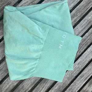 Mintgröna leggings från GTN - Snygga mintgröna leggings från NVGTN med hög midja och bred ribbad linning. Tillverkade i en mjuk och stretchig mix av nylon och spandex som sitter skönt på kroppen. Perfekta för träning eller chill dagar. Passar även S