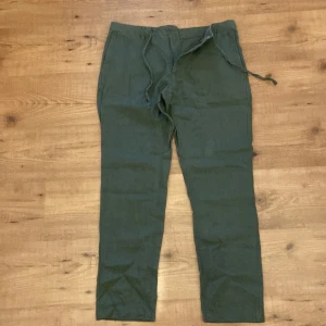Gröna linnebyxor från Gant, relaxed fit - Snygga gröna linnebyxor från Gant i relaxed fit. Byxorna har dragsko i midjan för extra skön passform och är tillverkade i ett luftigt linnematerial. Perfekta för en chill och stilren look.
