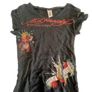 Svart Ed Hardy topp med tryck - ed Hardy topp köpt på vinted, ändå defekter skulle vara några få diamanter är borta, inget märkvärdigt.