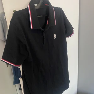 Svart Moncler pikétröja med röd/vit kant - Ny moncler polo använd 2 gånger storlek m 