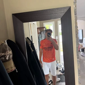 Real Madrid Bellingham orange tröja - Snygg orange Real Madrid fotbollströja från Adidas med Bellingham och nummer 5 på ryggen. Tröjan har go kvalité med Jude Bellingham på, helt oanvänd !