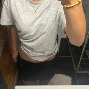 Svart tight kortkjol - Enkel och stilren svart kortkjol med tight passform. Perfekt att matcha med en t-shirt eller crop top för en clean look. Kjolen har en klassisk design utan synliga detaljer eller mönster.