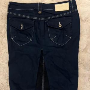 Mörkblå jeanskjol med slits - Mörkblå jeanskjol från med snygga kontrastsömmar, två bakfickor samt en slits bak