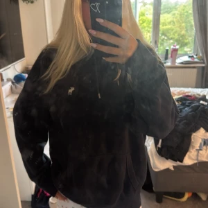 Mörkblå fleecehoodie Abercrombie - Mysig mörkblå hoodie från Abercrombie & Fitch i storlek L. Tröjan har en broderad logga på bröstet, huva med snörning och en stor känguruficka. Insidan av luvan är fodrad med supermjuk fleece som gör den extra varm och skön. Perfekt för kyliga dagar. 💕