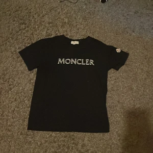 Svart Moncler t-shirt  - En Riksfet moncler T-shirt i svart/mörkblå. Den är helt oanvänd i toppskick för ett dunder pris. Kom dm för mer info 👍💯