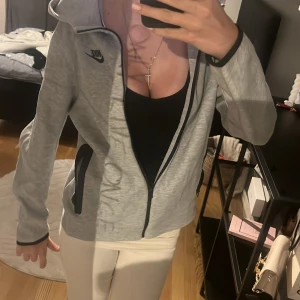 grå nike tech  - Säljer en grå nike tech i storlek XL (barn) upp till 170cm, använd några gånger, inga fläckar nånstans. köpt i butik JD sports för 1040kr 