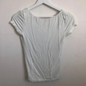 Vit kortärmad topp med djup rygg - Vit topp med djup rygg från Gina!