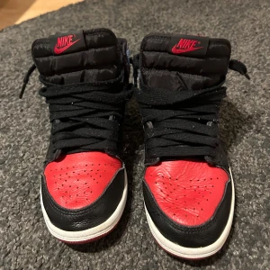 Jordan 1 UNC to CHI - Ikoniska Jordan 1 Mid “UNC to CHI” – en unik och eftertraktad design som hyllar både University of North Carolina och Chicago Bulls. Med sin kombination av ljusblått och rödsvart läder, ger dessa sneakers en stilren och sportig look. Perfekta för sneakerheads eller för den som vill ge sin skogarderob en uppgradering.