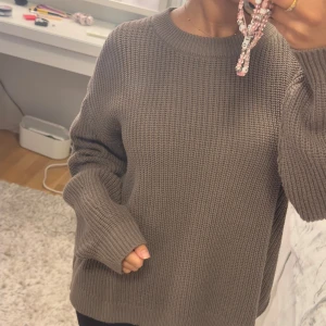 Brun stickad oversized tröja - Säljer en brun stickad tröja med grov struktur och rund hals. Modellen är oversized med långa ärmar och breda muddar vid ärmslut och nederkant. Perfekt för dig som gillar en chill och comfy stil.