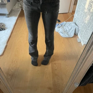 Svarta jeans från Gina Tricot - Snygga svarta jeans från Gina Tricot med en klassisk femficksdesign. De har en bekväm passform och är perfekta för en stilren look. Jeansen har en knapp och dragkedja framtill.